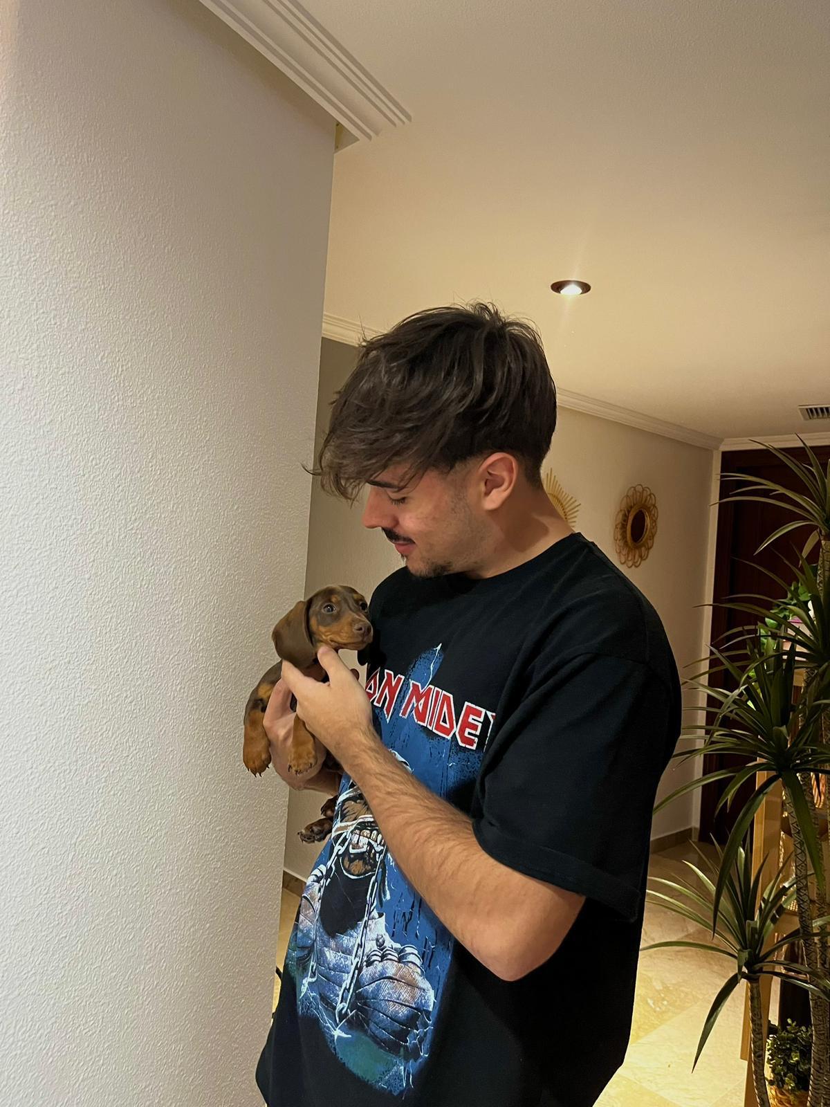 A woman smiling while holding a small dog.